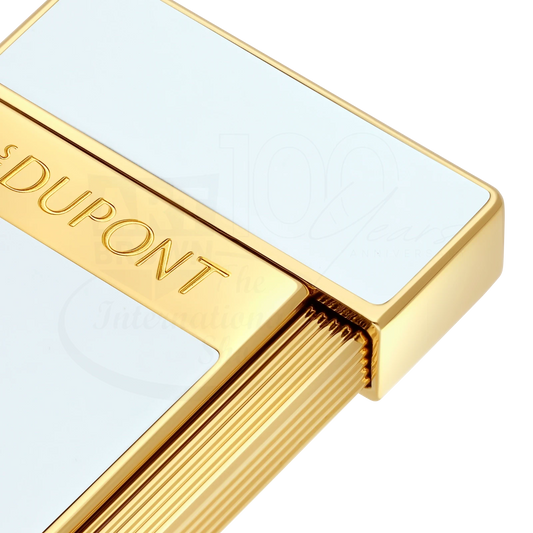 Close-up of S.T. Dupont slimmy white lacquer and gold lighter with elegant engraved branding and textured trigger design
