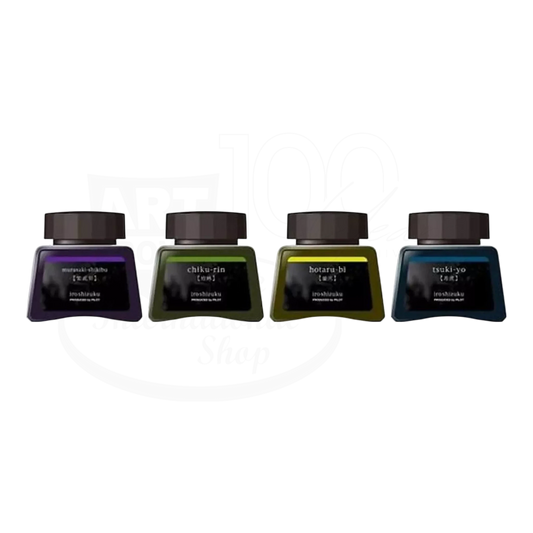 Pilot Iroshizuku ink bottles in purple, green, yellow, and blue glass jars with black caps lined up side by side