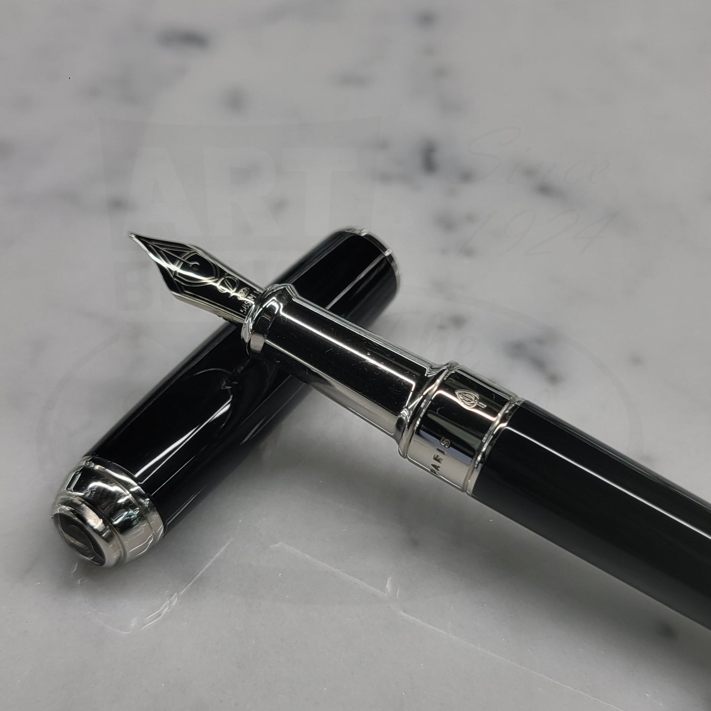 Fountain pen grip and nib resting on black lacquer cap with palladium accents. S.T. Dupont Line D Medium fountain pen 410100M