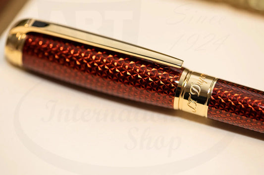 S.T. Dupont Line D 412111L brass rollerball pen featuring amber lacquered guilloche pattern with gold-tone accents and clip