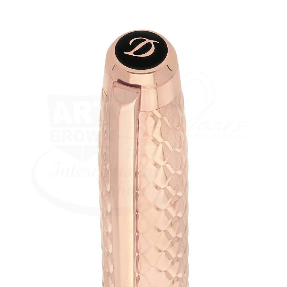 Rose gold guilloche pen cap with intricate dragon scale pattern and black emblem featuring a cursive letter D.
