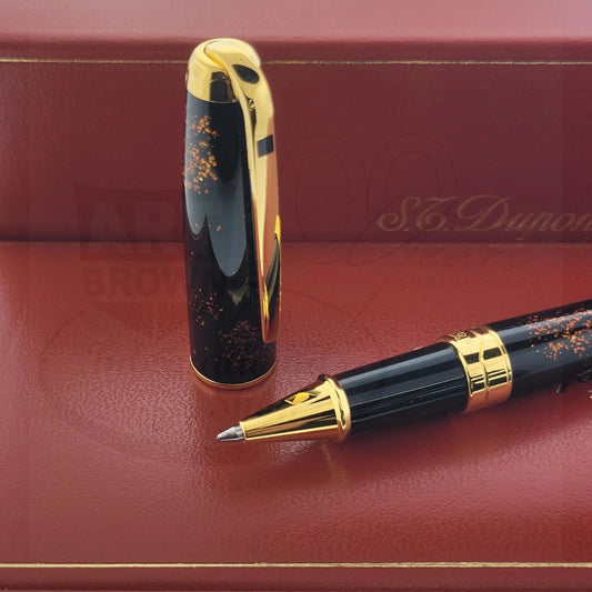S.T. Dupont Olympio 482590 rollerball pen, sitting beside cap, with black lacquer and gold speckled dust finish, gold trim close-up