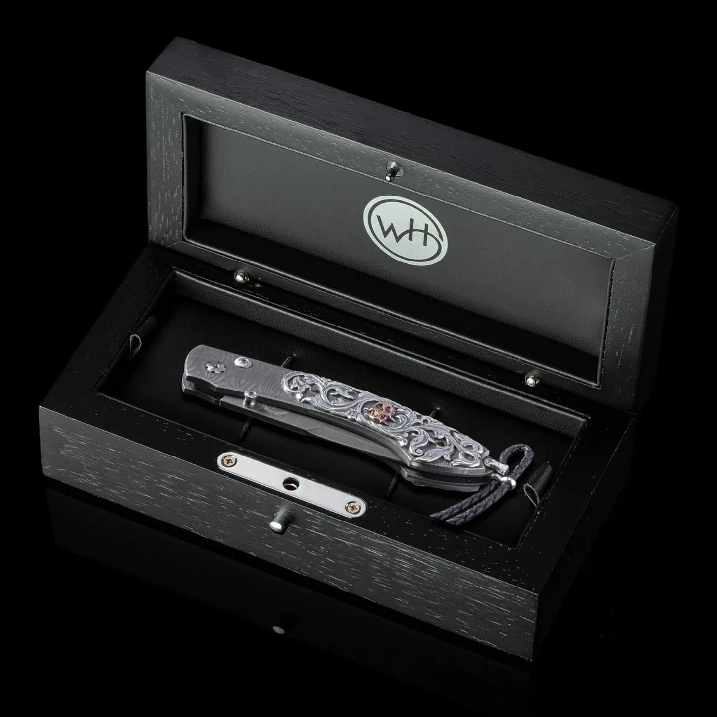 William Henry B12 Skulking Spearpoint folding knife with engraved metal handle and decorative bronze accent in black wood case