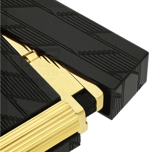 Close-up of a black and gold luxury guilloche cigar lighter with intricate engraved patterns and textured grip.