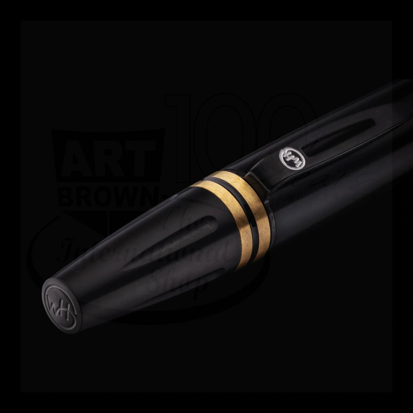 Close-up of a sleek black executive ballpoint pen with gold accent rings and a polished clip detail