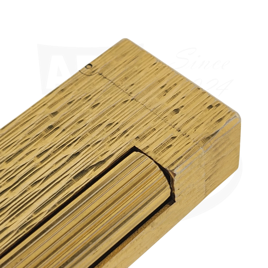 Close up of corner of gold plated Dunhill rollagas lighter with fine bark. pattern