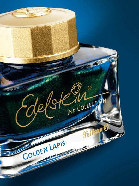 Pelikan Ink of the Year 2024, Golden Lapis, seen in the bottle from an angle showing floating gold flakes on blue background