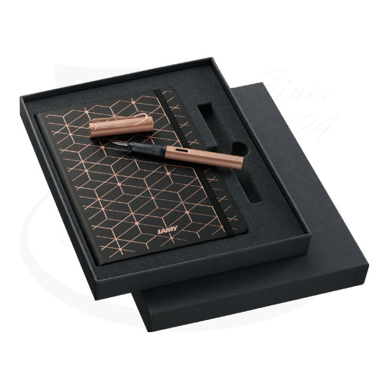 LAMY LX L76FS rose gold aluminum fountain pen with matching black notebook featuring geometric rose gold pattern, displayed in black gift box