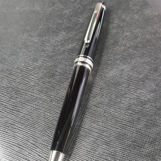 Montblanc Meisterstuck 146 ballpoint pen in black resin and platinum-plated trim, featuring classic cigar-shaped barrel on textured gray surface