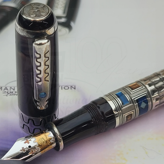 Close-up of a luxury fountain pen with intricate silver and colorful geometric detailing and a decorative nib.