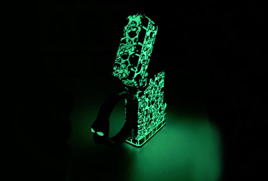 ST Dupont Ligne 2 016387 bronze lighter with luminous green skull pattern and spinner ring, glowing in dark, showing phosphorescent Luminova coating