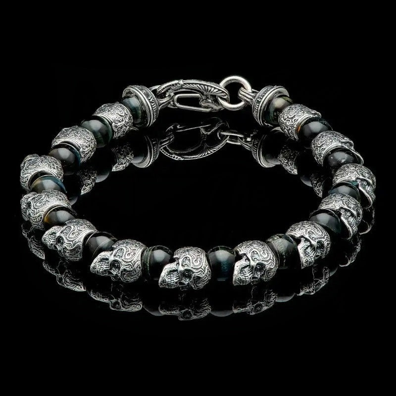 William Henry Hawkeye bracelet featuring sterling silver skull beads alternating with blue tiger eye stones, secured with silver clasp on steel cable