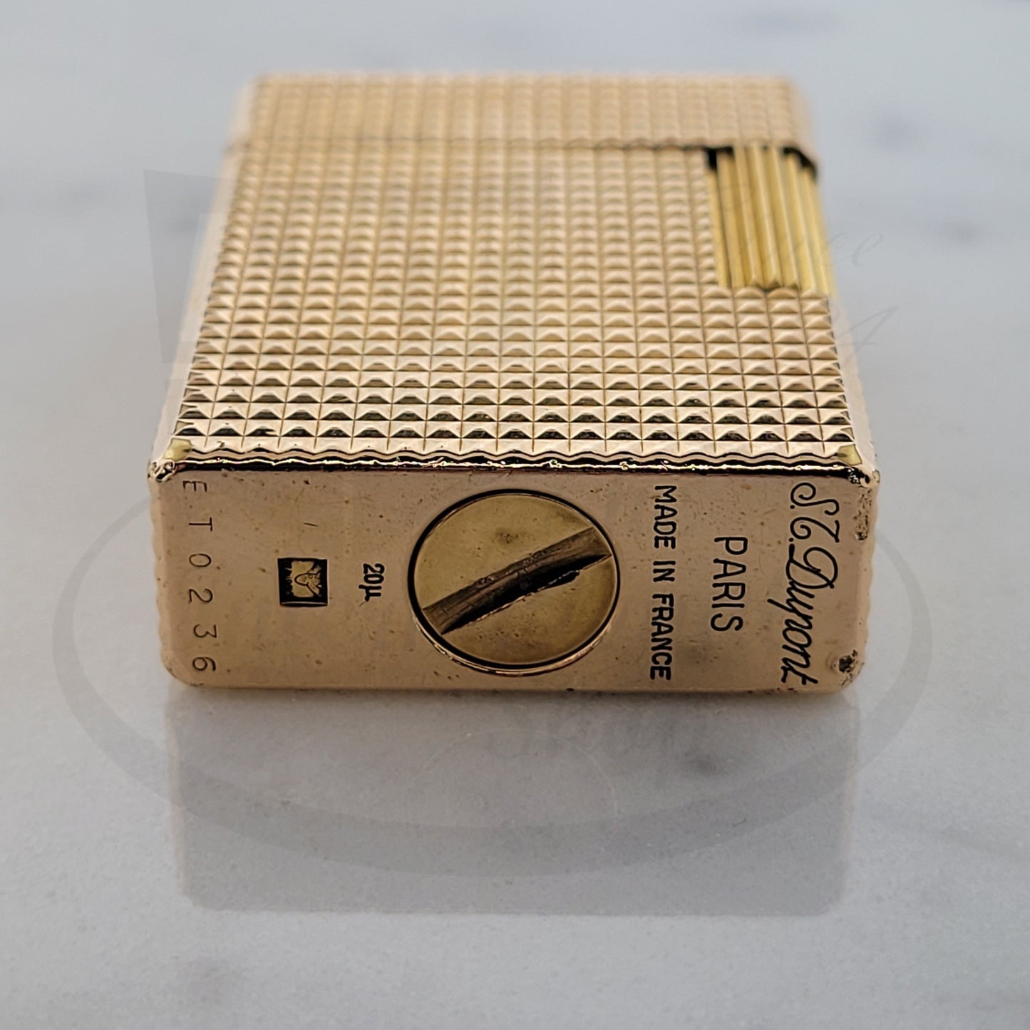 S.T. Dupont Ligne 1 gold-plated lighter with diamond head guilloche pattern, vintage rectangular design with textured surface and distinctive side ignition