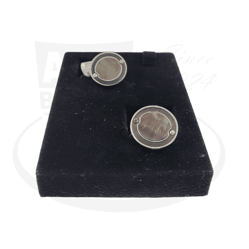 Stephen Webster Sterling Silver cufflinks with round black mother of pearl inlays displayed on black velvet cushion, featuring modern circular design with silver frame
