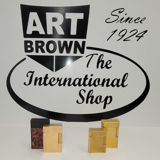 S.T. Dupont ligne 1 and ligne 2 lighters in front of Art Brown logo on white background.