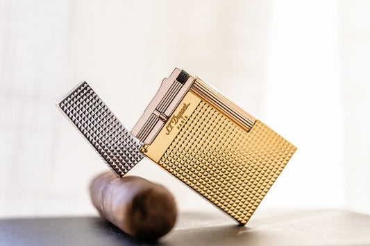 S.T. Dupont tri-colored Golden Hour lighter resting on a cigar.