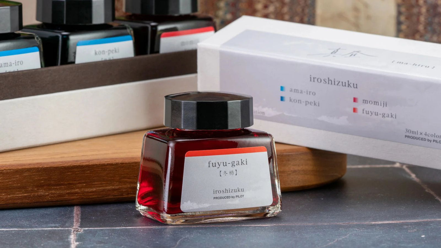 Pilot Iroshizuku green ink bottle Sui-Gyoku with emerald stones in the background.
