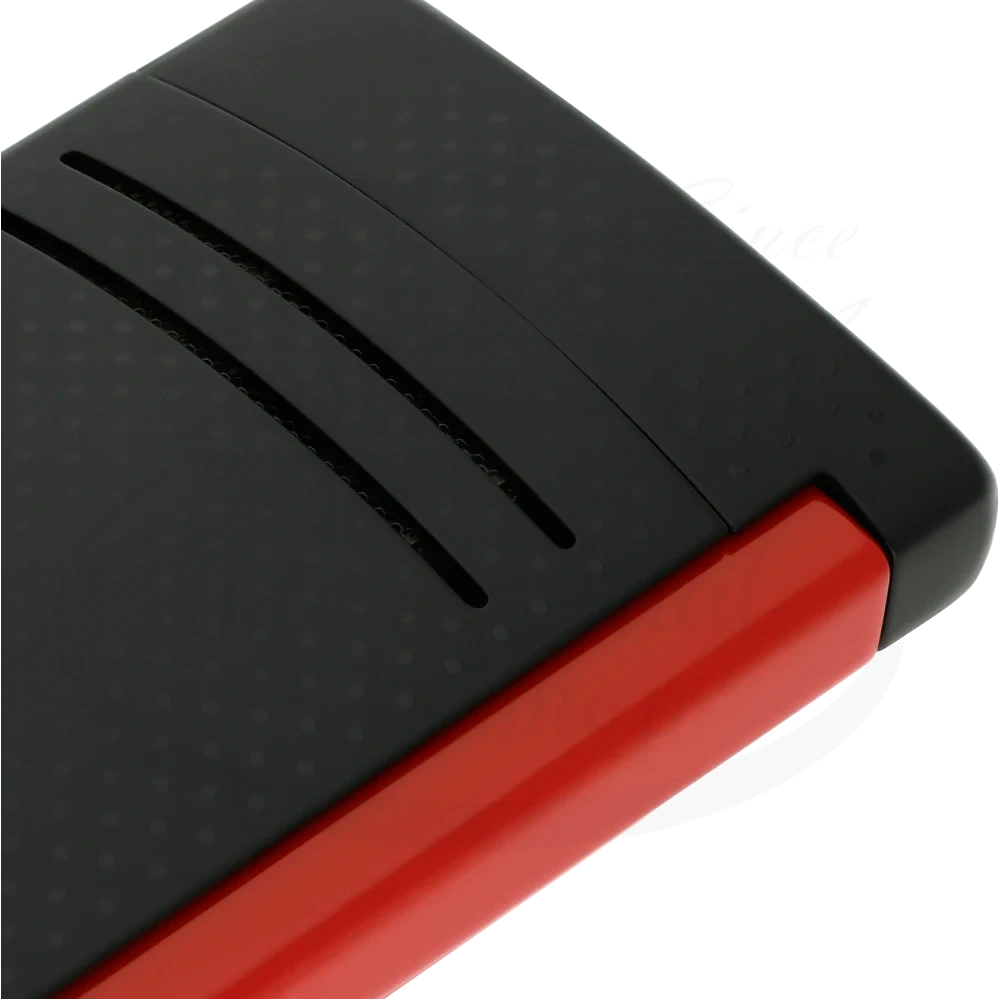 Corner of S.T. Dupont Maxijet torch lighter with red and black punched pattern.