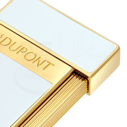 Close-up of S.T. Dupont slimmy white lacquer and gold lighter with elegant engraved branding and textured trigger design