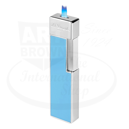 S.T. Dupont Twiggy Shiny Light Blue Lacquer & Chrome Lighter featuring a sleek vertical design with chrome accents and light blue lacquer finish, displaying an elegant torch flame against white background. Luxury lighter showcasing refined craftsmanship and 1960s-inspired aesthetics.