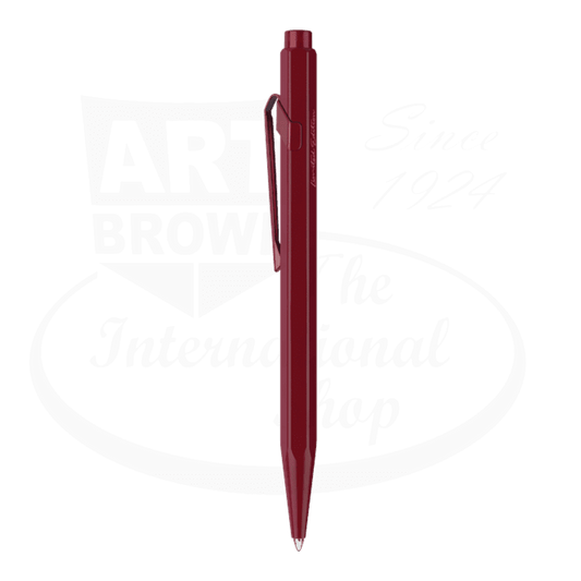 Caran D'Ache 849 metal ballpoint pen in garnet red with matching clip, featuring satin finish body and metallic accents