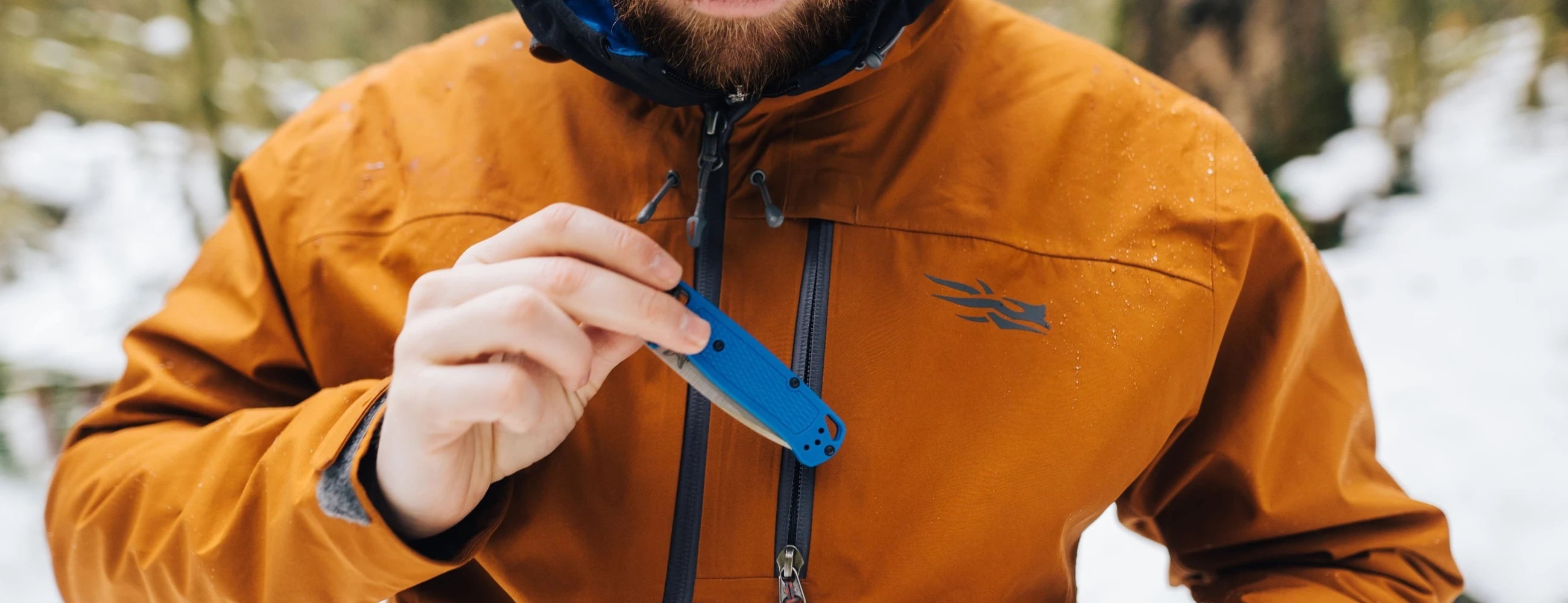 Benchmade Bugout EDC folding knife being placed into a pocket outside 
