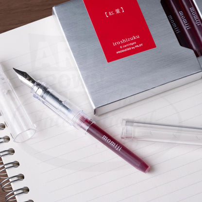 Pilot Iroshizuku 6-cartridge pack in red and silver packaging with transparent fountain pen displaying burgundy ink cartridge on lined paper