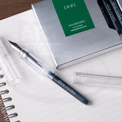 Pilot Iroshizuku plastic ink cartridge 6-pack in green packaging with transparent fountain pen display on lined notebook paper.