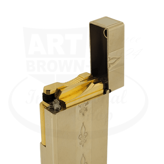 S.T. Dupont Ligne 1 brass-plated petrol lighter with engraved Fleur-de-Lis pattern, rectangular shape, open lid showing internal mechanism in gold finish