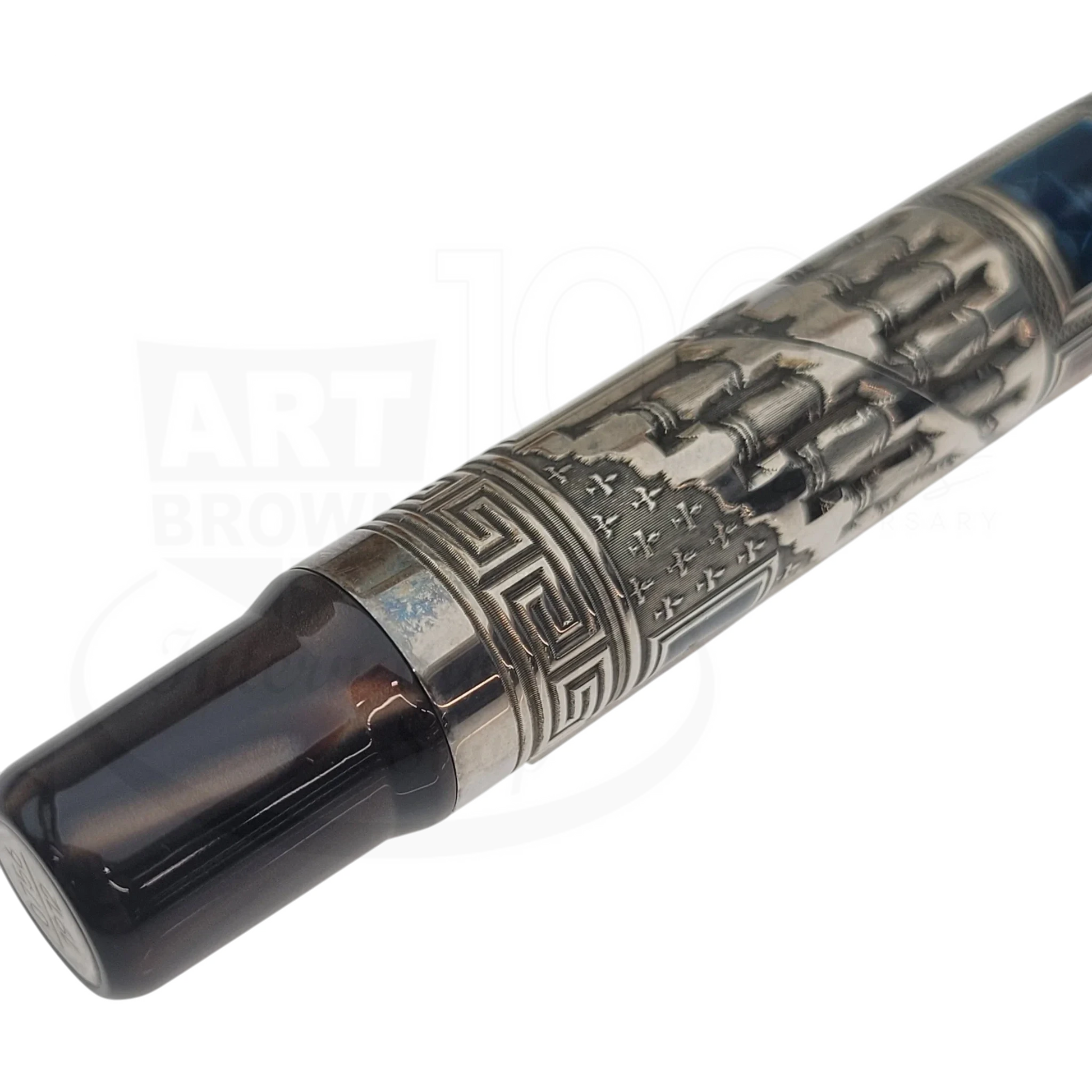 Close-up of a luxury fountain pen with intricate metal engravings and a dark resin grip section