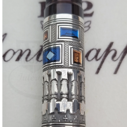 Detailed silver fountain pen barrel with intricate blue and copper guilloche inlays and textured engravings.
