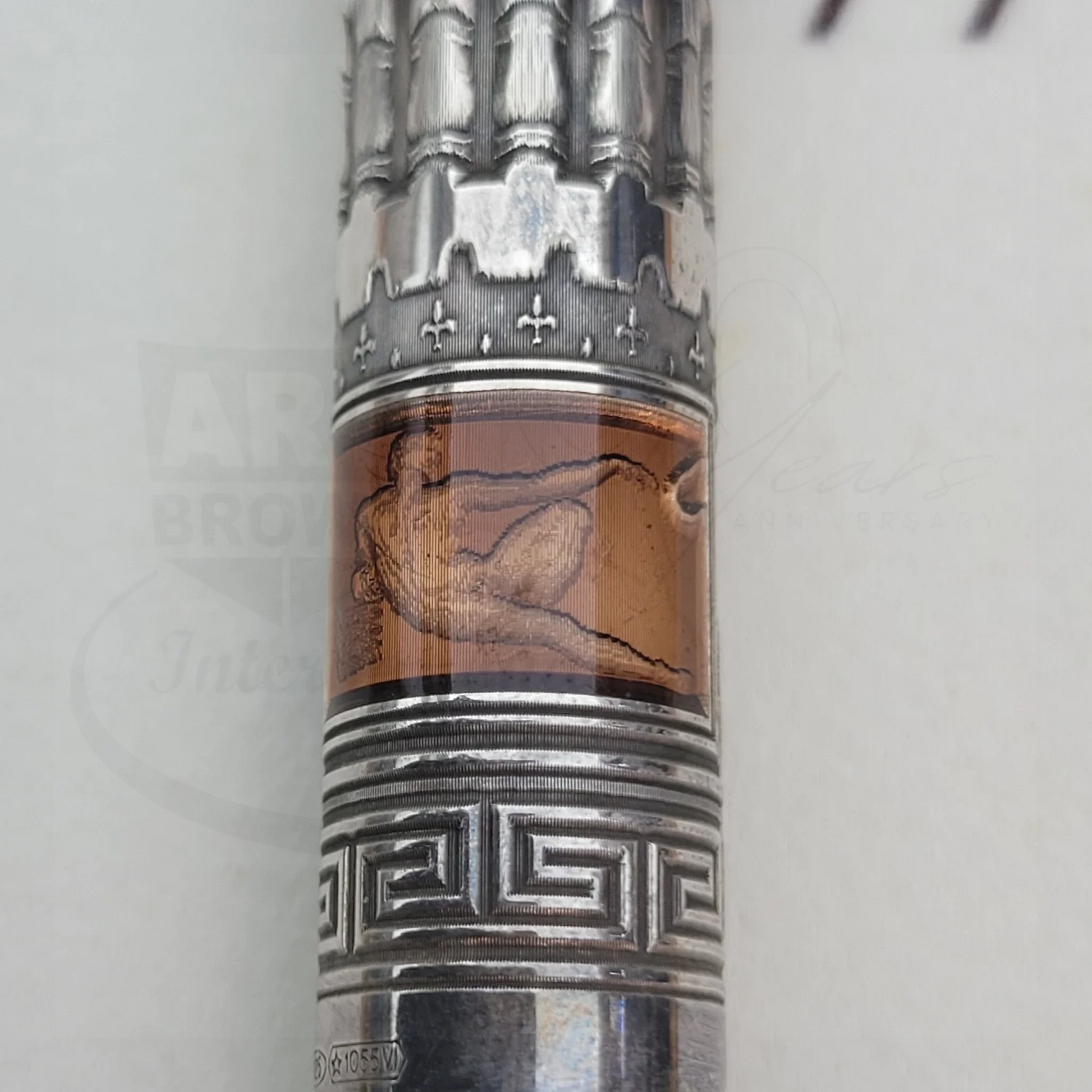 Close-up of an intricate silver and amber detailed section on a luxury fountain pen barrel