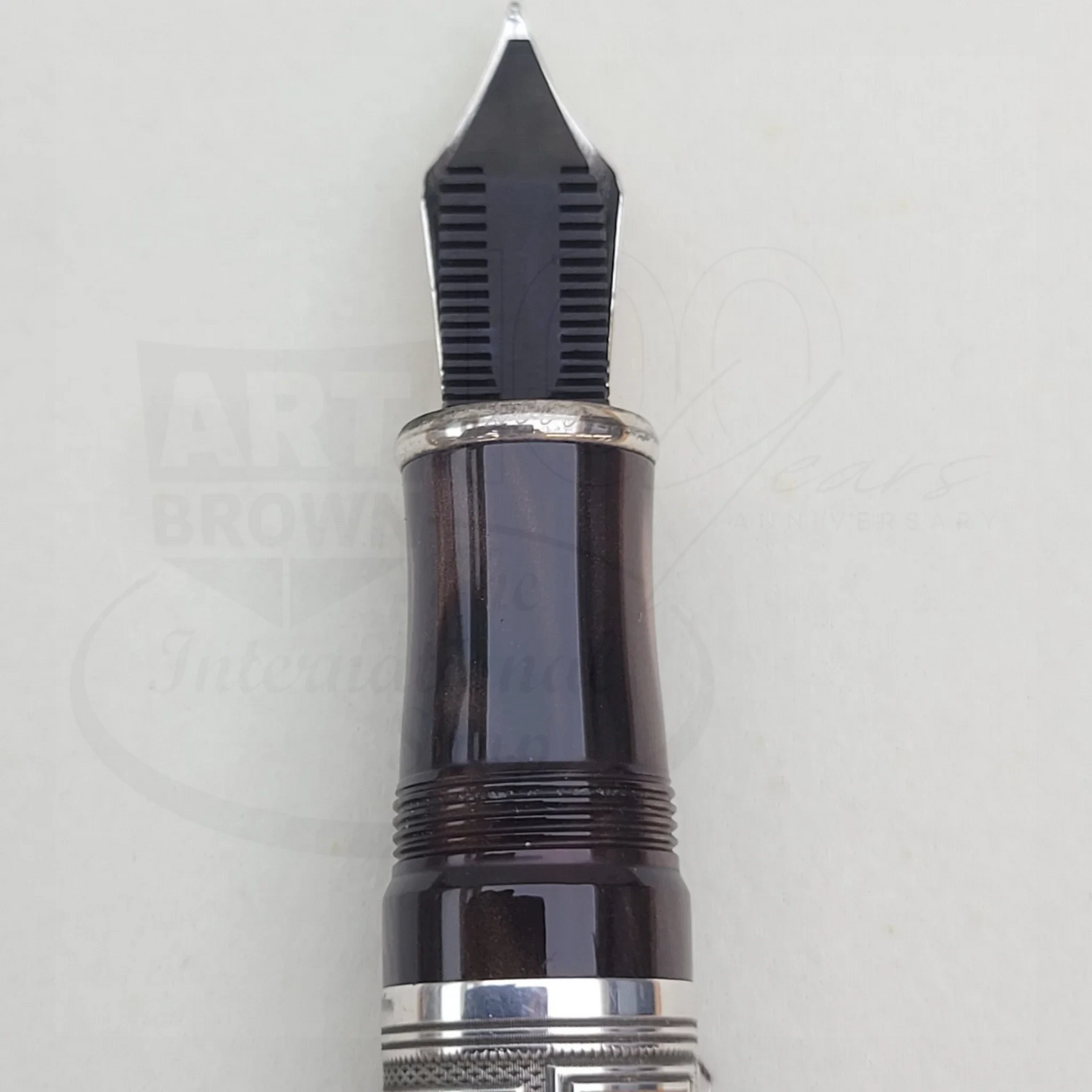 Close-up of a luxury fountain pen nib and grip section with silver detailing and polished black resin finish