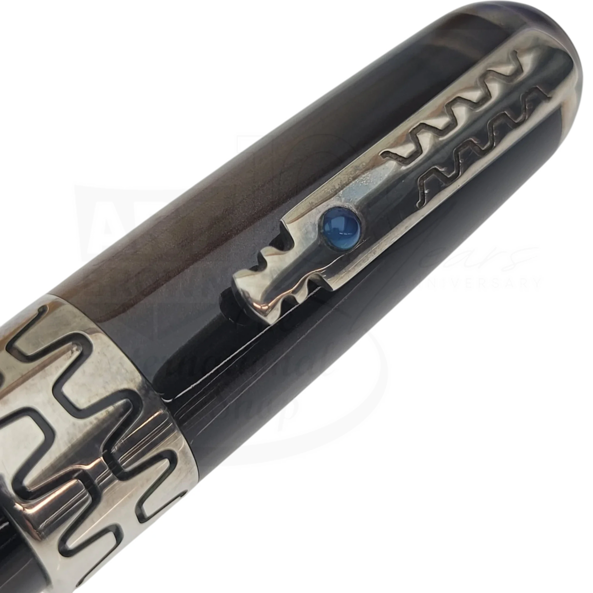 Close-up of luxury fountain pen clip with intricate metal design and dark polished barrel detail.