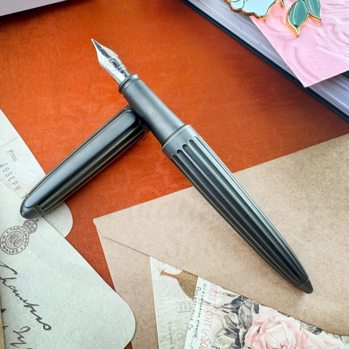 Diplomat Aero Oxyd Brass D40322025 fountain pen with ribbed dark brass body and silver nib on vintage paper background