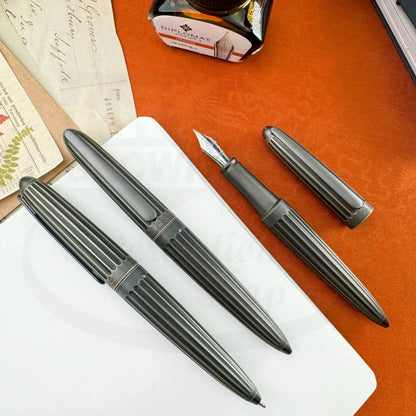 Diplomat Aero Oxyd Brass D40322025 fountain pen set with ribbed oxidized brass body and silver nib on white and orange background