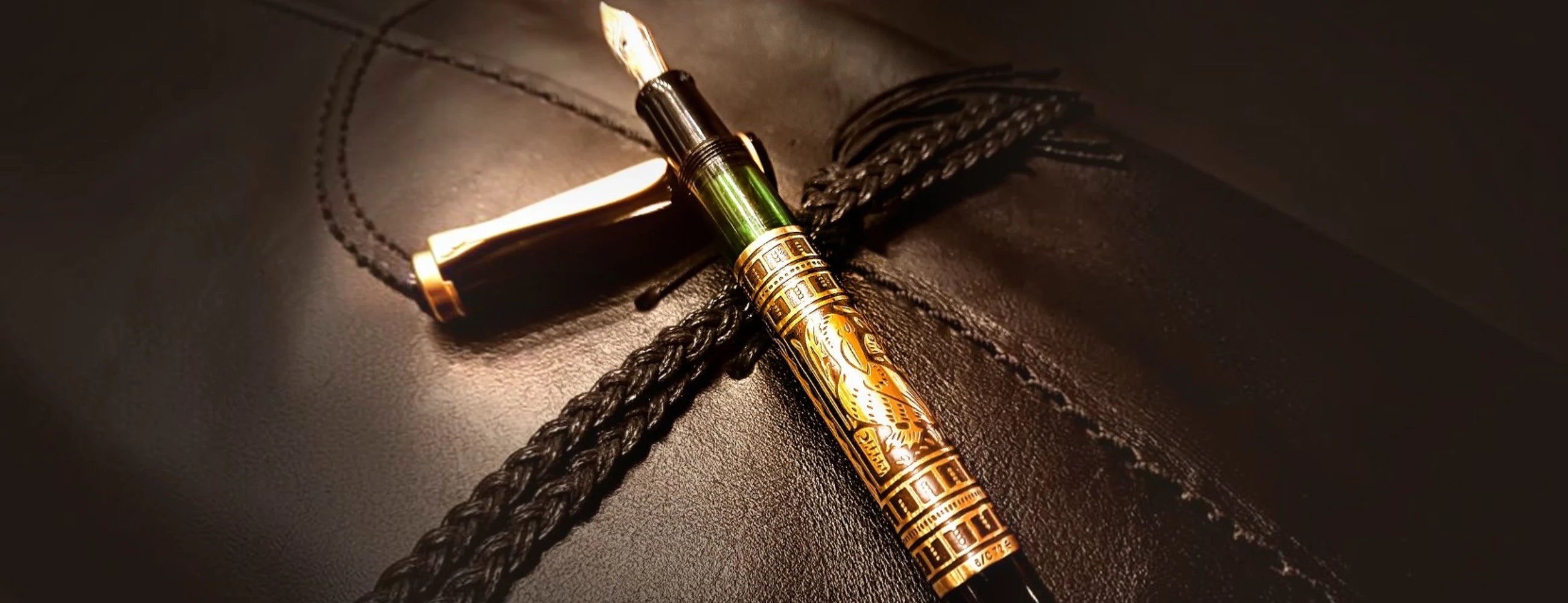 Pelikan Toledo fountain pen with gold accents sitting on a leather book.