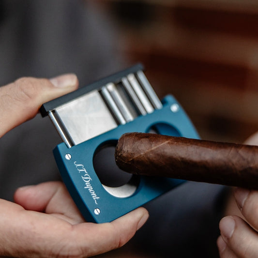 S.T. Dupont 003433 petrol blue chrome double-blade cigar cutter with V-cut and straight blade demonstrating cut on cigar