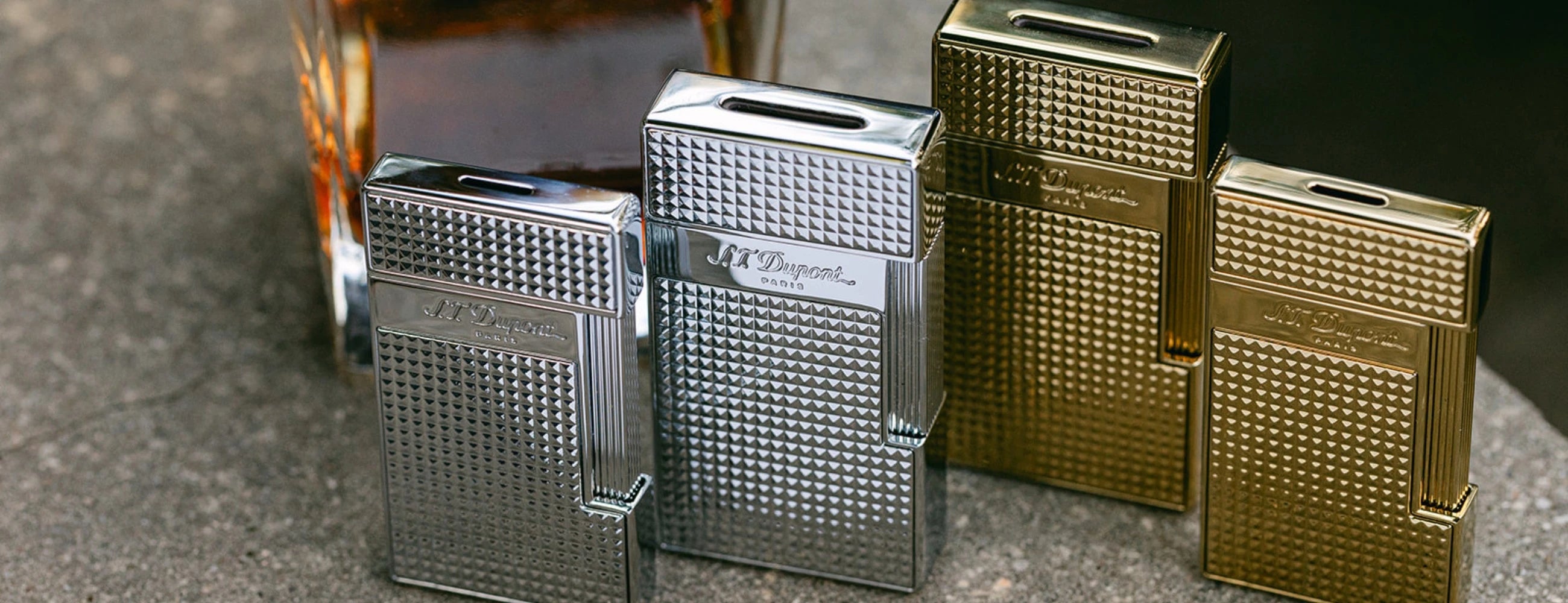 S.T. Dupont Biggy and Slimmy premium jet lighters in chrome and gold finishes.