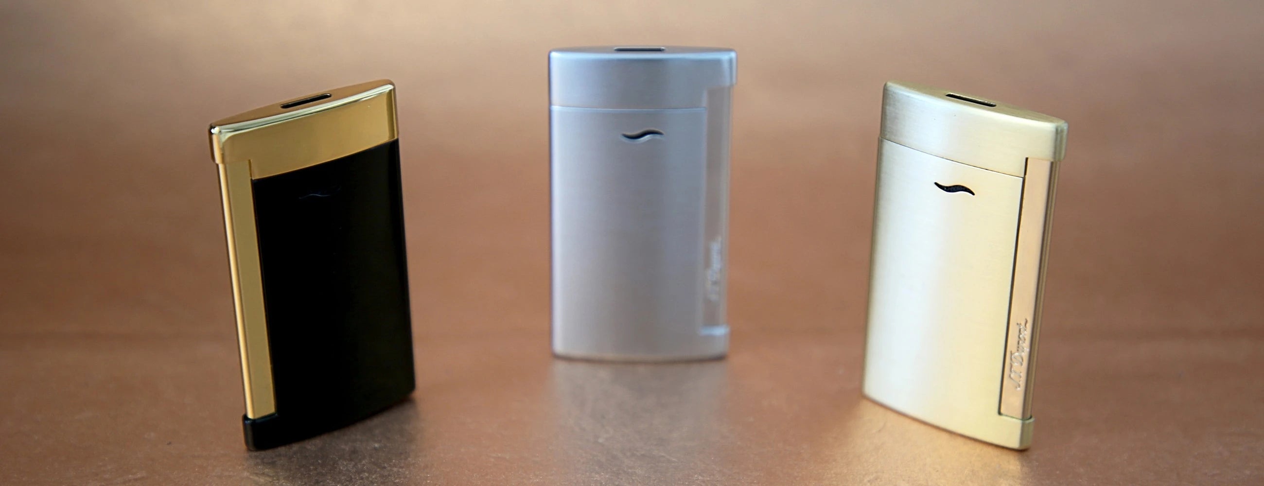 Collection of S.T,. Dupont slim 7 torch lighters in black & gold, brushed chrome and brushed gold finishes.