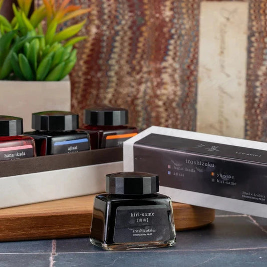 Pilot Iroshizuku Yu-Gure glass ink set featuring four 30ml bottles in pink, blue, orange, and gray, displayed with luxury box on wooden surface