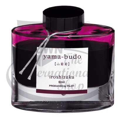 Pilot Iroshizuku Yama-budo glass bottle fountain pen ink in vibrant magenta purple, featuring black cap and decorative silver cord, 50ml capacity